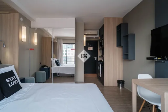 Home office em apartamento moderno com mesa, computador e janela com vista urbana