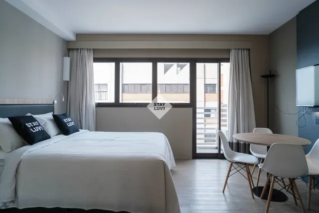 Apartamento de temporada com vista para janela e mesa de trabalho organizada