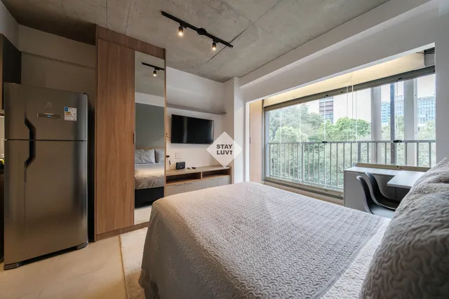 Quarto de apartamento mobiliado com cama de casal e decoração neutra e acolhedora