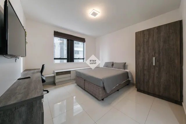 Cozinha aberta integrada à sala em apartamento mobiliado para temporada