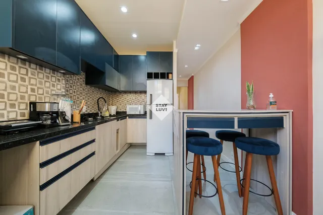 Apartamento moderno com sala ampla, sofá claro e janelas para área verde de condomínio em Alphaville