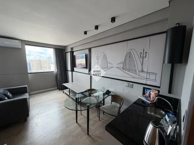 Cozinha americana de apartamento com eletrodomésticos organizados e bancada limpa