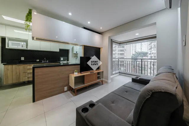 Quarto de imóvel de temporada com cama de casal arrumada e janela com luz natural